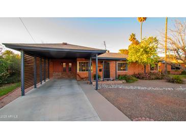 Charming single-story brick home featuring a covered carport and desert landscaping at 824 W Luke Ave, Phoenix, AZ 85013