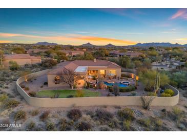 Stunning backyard featuring a pool, spa, patio, and lush landscaping with beautiful desert views at 8320 E Arroyo Hondo Rd, Scottsdale, AZ 85266