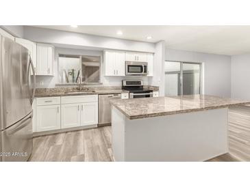 Updated kitchen boasts stainless steel appliances and an island with granite countertops, offering both style and functionality at 8558 E Indian School Rd # H, Scottsdale, AZ 85251