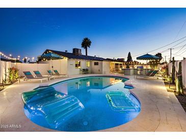 Inviting backyard pool area featuring an in-ground pool, lounge chairs, and manicured landscaping under a twilight sky at 8640 E Dianna Dr, Scottsdale, AZ 85254