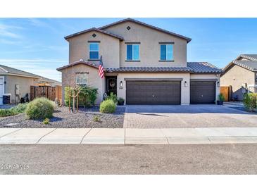 Two-story home featuring a three-car garage, desert landscaping, and a welcoming front entrance at 13307 W Paso Trl, Peoria, AZ 85383
