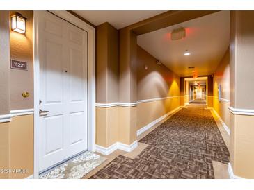 Hallway with a carpeted floor leads to the unit, adjacent to the unit number on the wall at 14575 W Mountain View Blvd # 11221, Surprise, AZ 85374