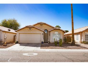 Charming single-story home featuring a desert landscaped front yard and an attached two-car garage at 2323 E Aire Libre Ave, Phoenix, AZ 85022