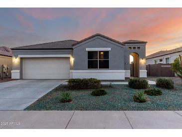 Charming single-story home showcasing a well-maintained front yard with desert landscaping and a two car garage at 30071 W Indianola Ave, Buckeye, AZ 85396