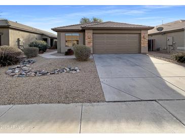 Charming single-story home with a low maintenance rock landscape, a two car garage, and tile roof at 517 S 125Th Ave, Avondale, AZ 85323