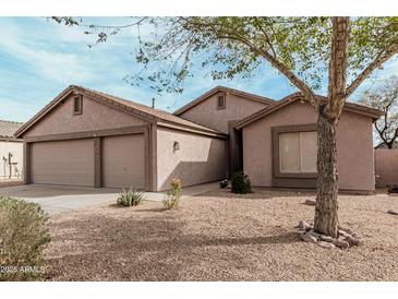 Charming single-story home showcasing a spacious two-car garage and desert landscaping at 6965 E Hacienda La Noria Ln, Gold Canyon, AZ 85118