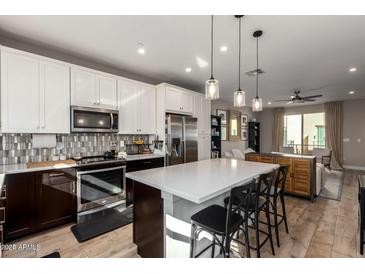 Modern kitchen with stainless steel appliances, a large island with seating and stylish pendant lighting at 820 N 8Th Ave # 14, Phoenix, AZ 85007