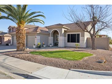 Charming single-story home featuring a well-manicured lawn, desert landscaping and a tile roof at 9 W Glenhaven Dr, Phoenix, AZ 85045