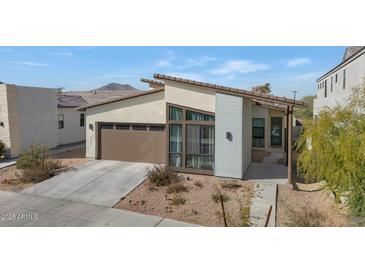 Stunning modern home featuring a clean desert landscape and a sleek, attached two car garage at 9422 S 7Th Pl, Phoenix, AZ 85042