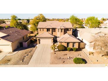 Two-story home features a two-car garage, landscaped front yard, and neutral color scheme at 122 W Raven Dr, Chandler, AZ 85286