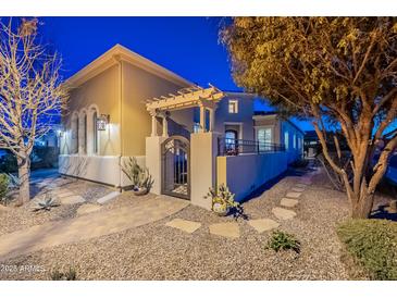 Charming home exterior with a lovely gated front entrance, stone pathway, and beautiful desert landscaping at 1275 E Verde Blvd, Queen Creek, AZ 85140