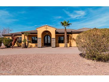 Inviting Mediterranean home boasts a barrel tile roof, stone accents, double door entry, and a manicured yard at 18332 W Latham St, Goodyear, AZ 85338