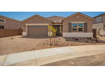 Charming single-story home with a low-maintenance front yard and brick-paved driveway leading to a two-car garage at 25372 N 158Th Ct, Surprise, AZ 85387