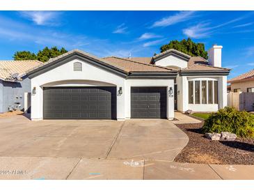 Charming single-story home features a three-car garage and well-manicured landscaping at 328 E Ivy St, Mesa, AZ 85201