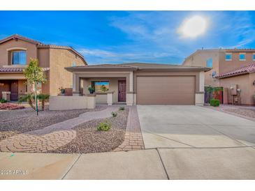 Charming single Gathering home with a well-manicured front yard and a two-car garage at 379 W Dragon Tree Ave, Queen Creek, AZ 85140