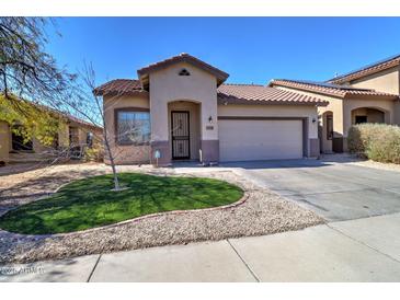 Charming single-story home featuring a well-manicured lawn and a two-car garage on a sunny day at 40716 N Hudson Trl, Anthem, AZ 85086