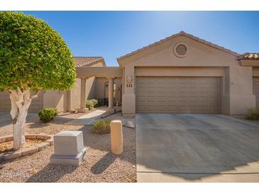 Single story home with a front-facing two car garage, desert landscaping, and an arched entryway at 4202 E Broadway Rd # 211, Mesa, AZ 85206