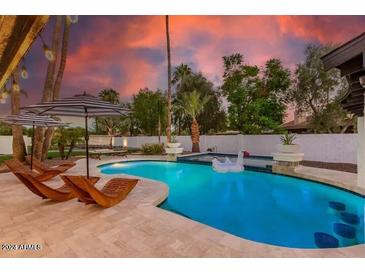 Inviting pool with lounge chairs and charming swan floatie, perfect for outdoor relaxation at 6601 E Hearn Rd, Scottsdale, AZ 85254