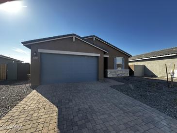 Charming single-story home with a two-car garage and a beautifully paved driveway on a sunny day at 6831 W Samantha Way, Laveen, AZ 85339