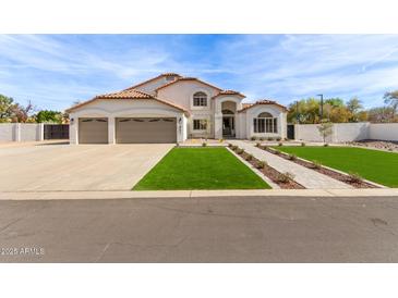 Charming two-story home featuring a three-car garage, manicured lawn, and beautiful desert landscaping at 951 N Poinciana Rd, Gilbert, AZ 85234