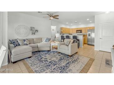 Comfortable living room featuring a sectional sofa, accent chair, and blue patterned rug open to the kitchen at 12050 N Panorama Dr # 107, Fountain Hills, AZ 85268