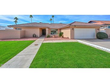 Charming single-story home featuring a well-manicured lawn and a two-car garage at 13014 N 23Rd Pl, Phoenix, AZ 85022