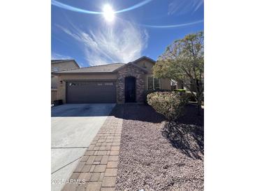 Charming single-story home featuring a stone-accented entrance, a two-car garage, and well-maintained landscaping at 13225 W Rowel Rd, Peoria, AZ 85383