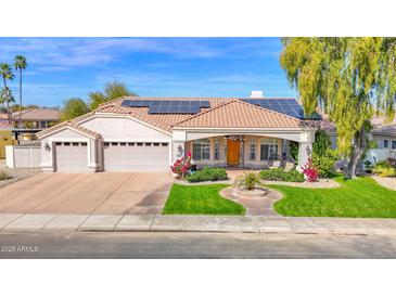 Charming home with a meticulously landscaped yard, solar panels, and a welcoming front porch at 13534 Fairway S Loop, Goodyear, AZ 85395