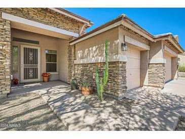 Charming single Gathering home featuring attractive stone accents, desert landscaping, and a welcoming front porch at 2730 W Via Calabria St, Phoenix, AZ 85086