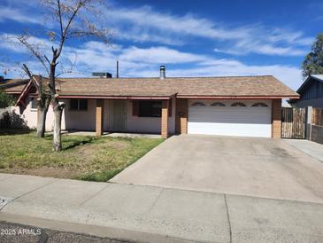 Single-story home featuring a driveway, garage, and landscaped front yard beneath a partly cloudy sky at 3618 W Las Palmaritas Dr, Phoenix, AZ 85051