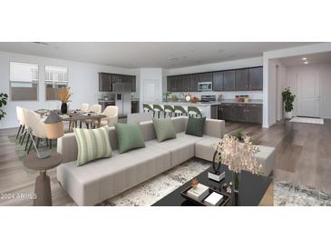 Bright, open-concept living space featuring a modern sectional sofa and stylish kitchen with breakfast bar seating at 4022 S 178Th Ln, Goodyear, AZ 85338