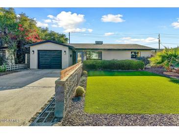 Charming home showcasing a well-manicured lawn and a nicely designed retaining wall at 4627 E Montecito Ave, Phoenix, AZ 85018