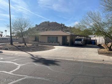 Single story home with a large front yard and driveway in front of a beautiful mountain view at 9804 N 5Th Ave, Phoenix, AZ 85021
