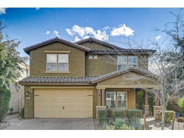 Charming two-story home featuring neutral-toned stucco and tile roof, with a 2-car garage and tidy landscaping at 10249 E Kinetic Dr, Mesa, AZ 85212