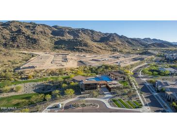 Stunning aerial view of a community pool and future home sites surrounded by desert landscape and mountains at 1111 E Mcneil St, Phoenix, AZ 85044