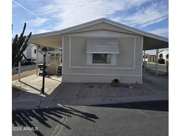 Charming manufactured home featuring an awning and xeriscaped front yard at 11411 N 91St Ave # 122, Peoria, AZ 85345