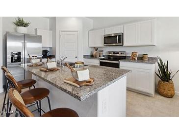 Bright kitchen features stainless steel appliances, granite countertops, and a convenient breakfast bar at 1350 W Kennedy Ave, Coolidge, AZ 85128