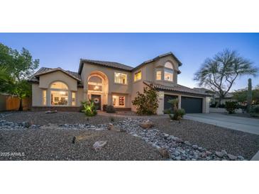 Stunning two-story home featuring a grand entrance, lush landscaping, and a charming rock river feature at 14052 S 24Th Way, Phoenix, AZ 85048