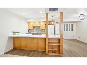 Bright kitchen featuring stainless steel appliances, light wood cabinets, white countertops, and sleek backsplash at 2117 W Pontiac Dr, Phoenix, AZ 85027