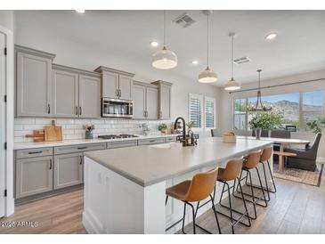 Beautiful kitchen featuring gray cabinetry, a spacious island, and stainless steel appliances at 21186 W Hillcrest Blvd, Buckeye, AZ 85396