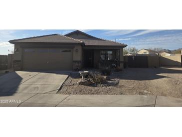 Charming single-story home featuring desert landscaping, a two-car garage, and neutral exterior paint at 23882 W Yavapi St, Buckeye, AZ 85326