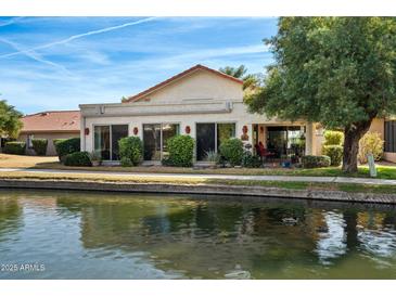 Charming waterfront property featuring large sliding glass doors and mature landscaping at 421 Leisure World --, Mesa, AZ 85206