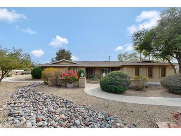 Charming single-story home featuring a landscaped front yard with desert landscaping and a brick walkway at 4349 E Stanford Dr, Phoenix, AZ 85018