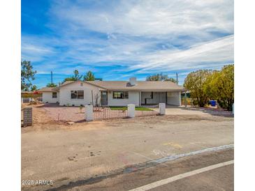 Charming home featuring a white brick exterior, carport, and freshly landscaped front yard at 6655 E Rustic Dr, Mesa, AZ 85215