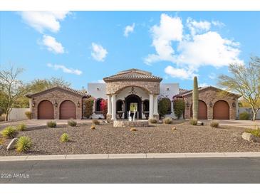 Beautiful home exterior with arched entryway, stone accents, fountain, and well-manicured desert landscaping at 8214 E Kael St, Mesa, AZ 85207