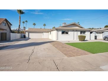 Charming single-story home with a spacious driveway, white paint, and a well-maintained front yard at 8432 E Keim Dr, Scottsdale, AZ 85250