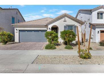 Charming single-story home with a two-car garage, desert landscaping, and neutral tones at 14254 W Cottontail Ln, Surprise, AZ 85387