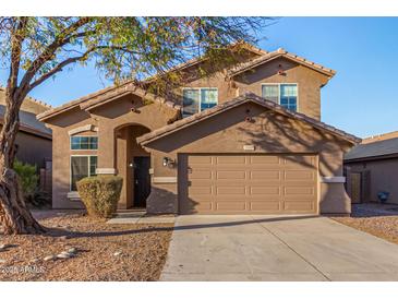 Charming two-story home with brown stucco, a tile roof and well-kept landscaping at 15466 W Shangri La Rd, Surprise, AZ 85379