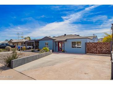 Charming blue home featuring a red front door and low maintenance desert landscaping at 217 W Montecito Ave, Phoenix, AZ 85013