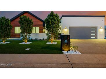 Contemporary home featuring a modern design, wood accents, manicured landscaping, and an attached garage at 2643 N Fiesta St, Scottsdale, AZ 85257